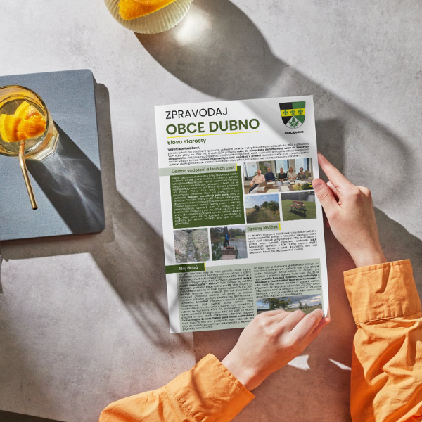 osoba drží v ruce zpravodaj obce Dubno